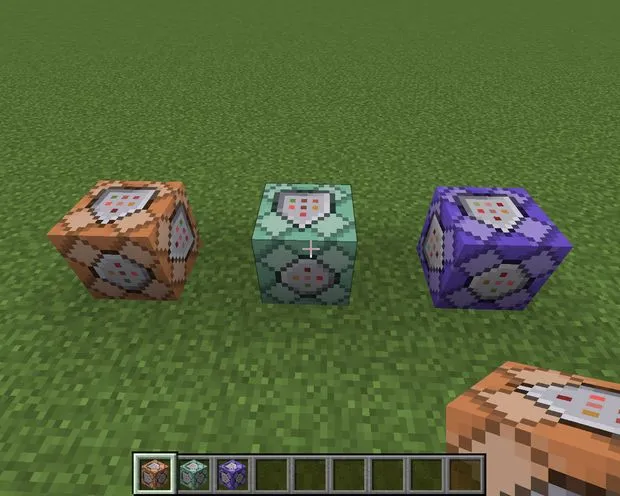 3 command blocks in different colors placed on the ground.