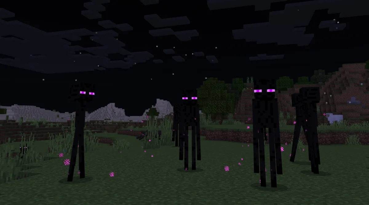 Four Endermen grouped together in the darkness.